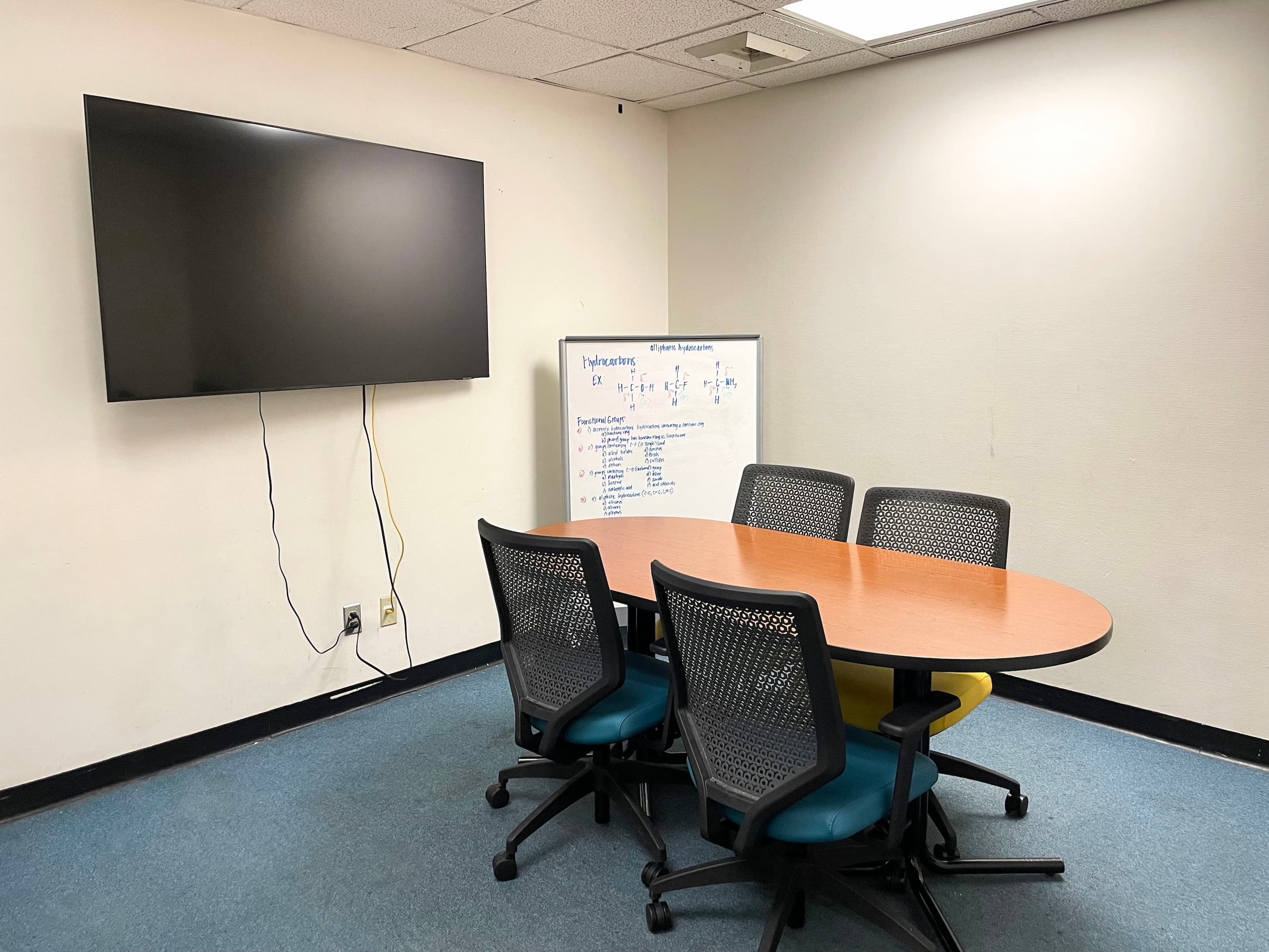 Study room with table, display and whiteboard.