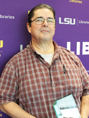 a man poses with a glass award indoors