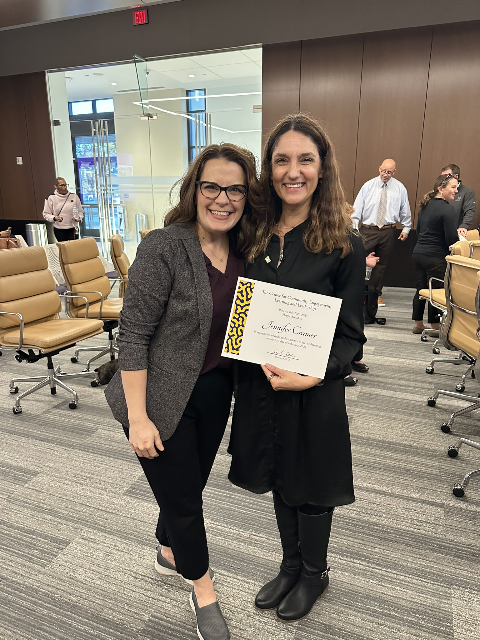 two women pose with a certificate