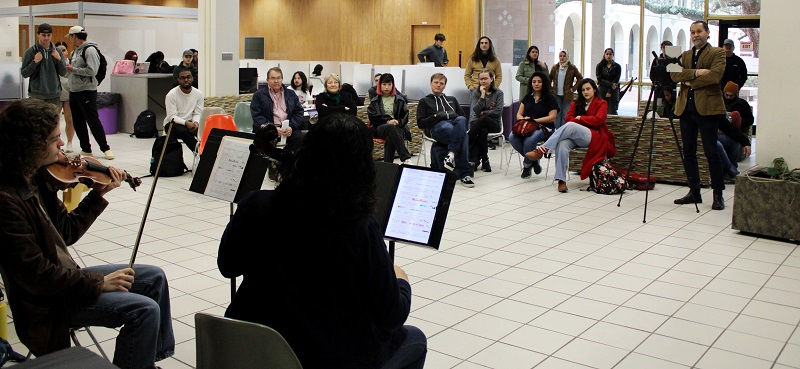 two musicians perform for an audience in the lobby of LSU Main Library